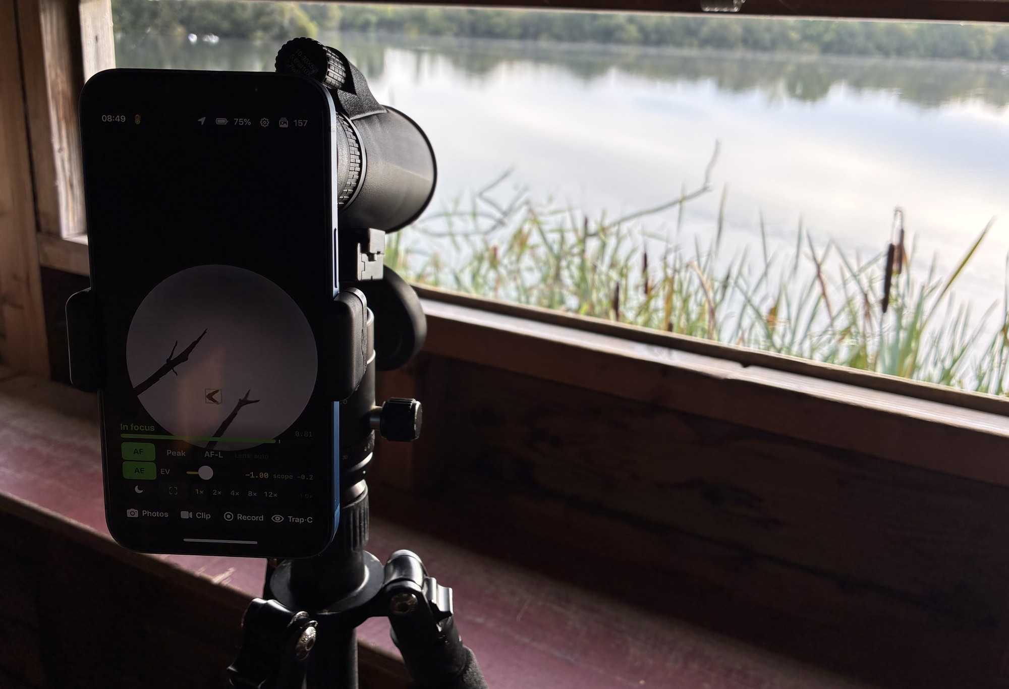 Torimado running on a phone at a scope’s eyepiece, with the lake behind it.
